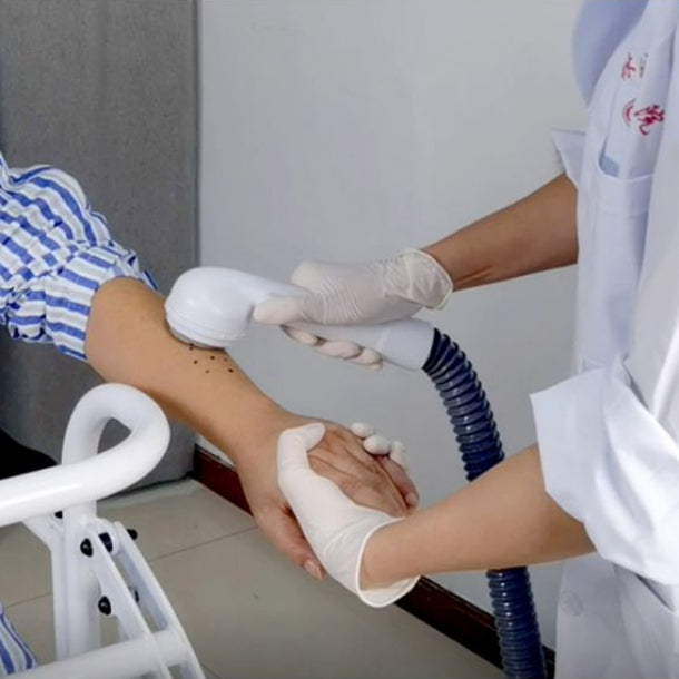 Person being washed with the Poertable Shower System with a healthcare professional in a medical setting.