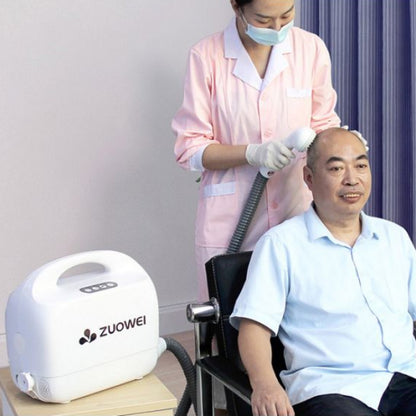Person using the Portable Shower System with another person having their hair washed.